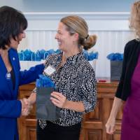 President Mantella shaking hands with faculty member as Jen